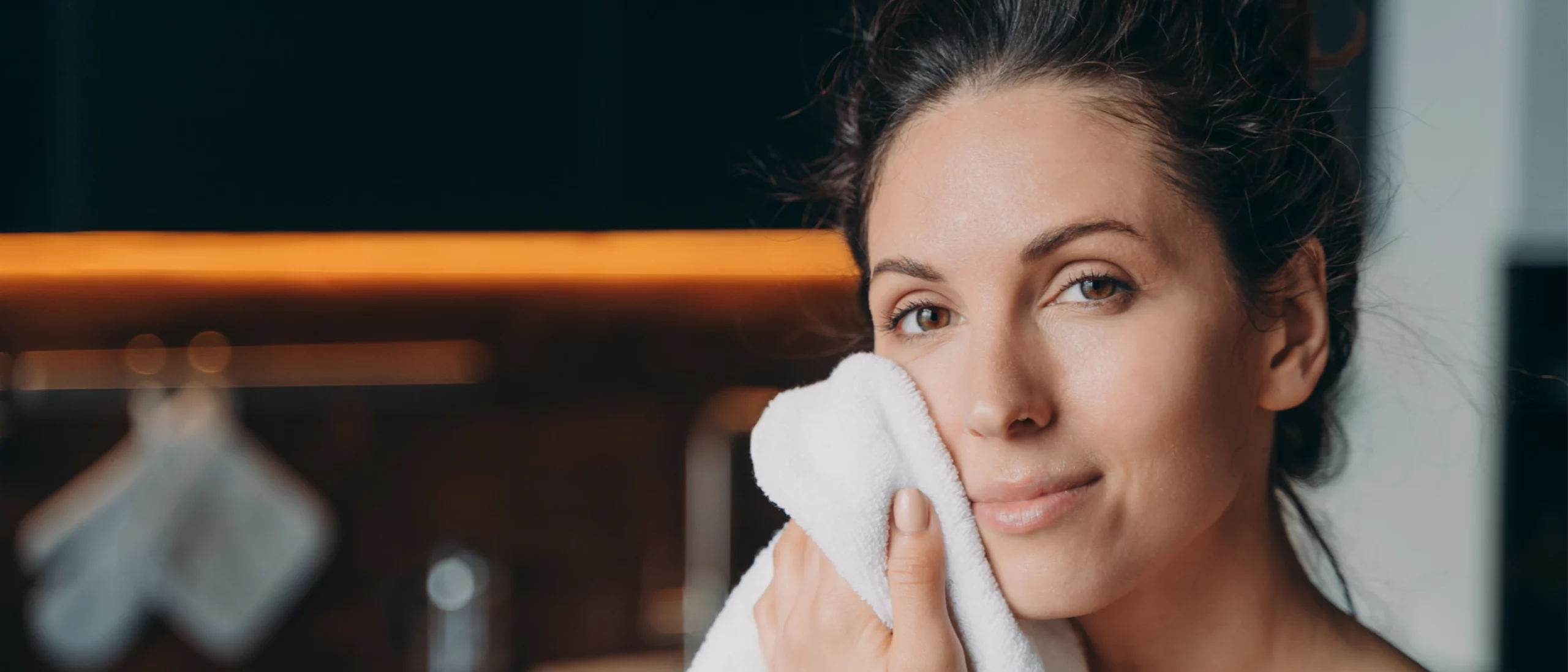 woman dabbing face with towel