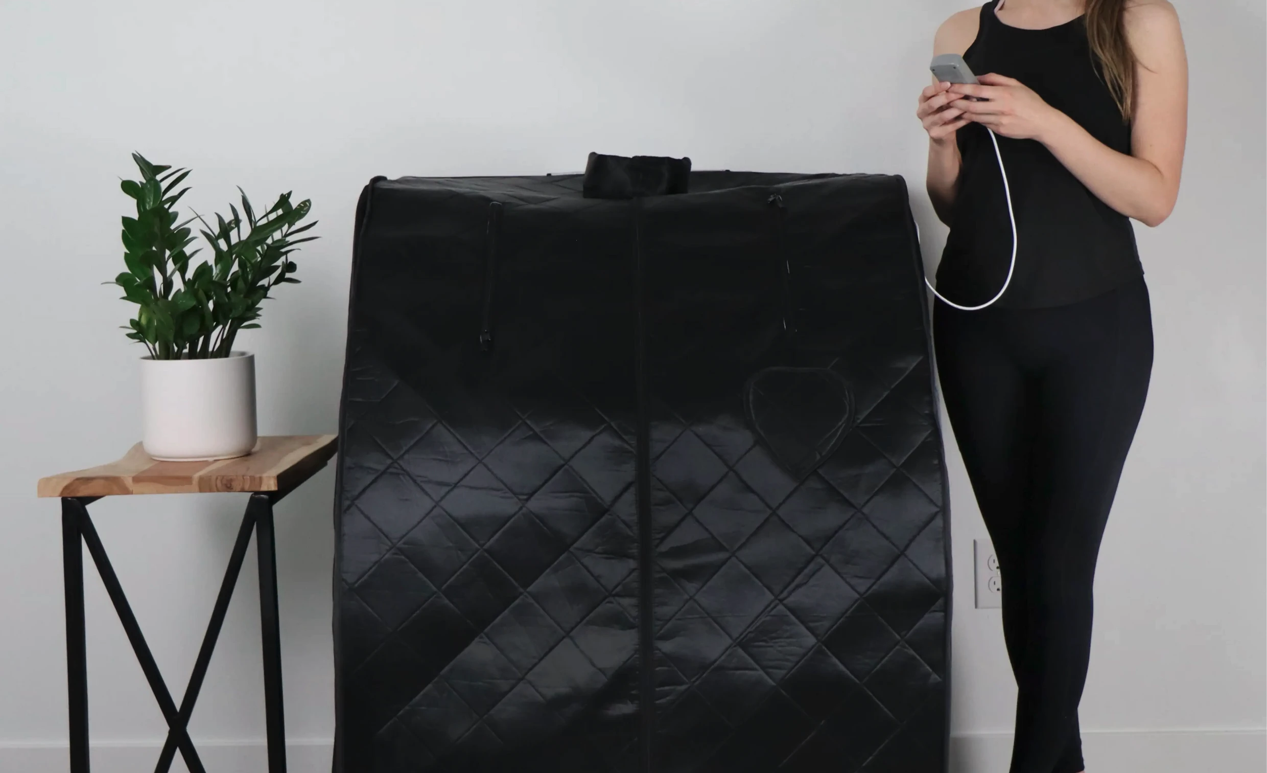 woman next to closed foldaway sauna