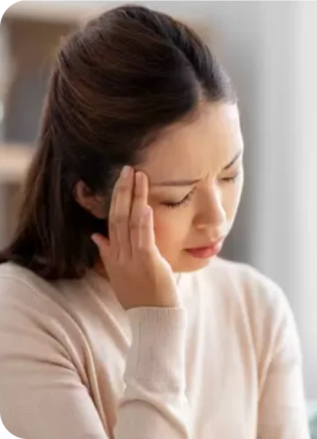 woman holding the side of her head in pain from a headache