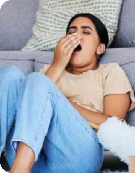 fatigued woman yawning sitting in front of a couch