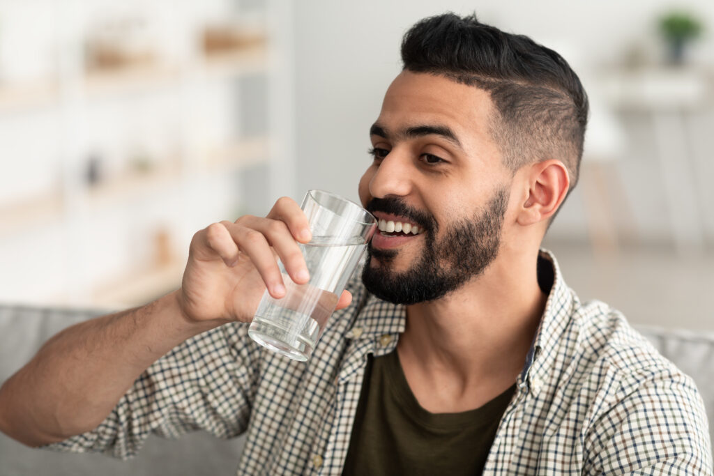 young man drinking from a glass of water