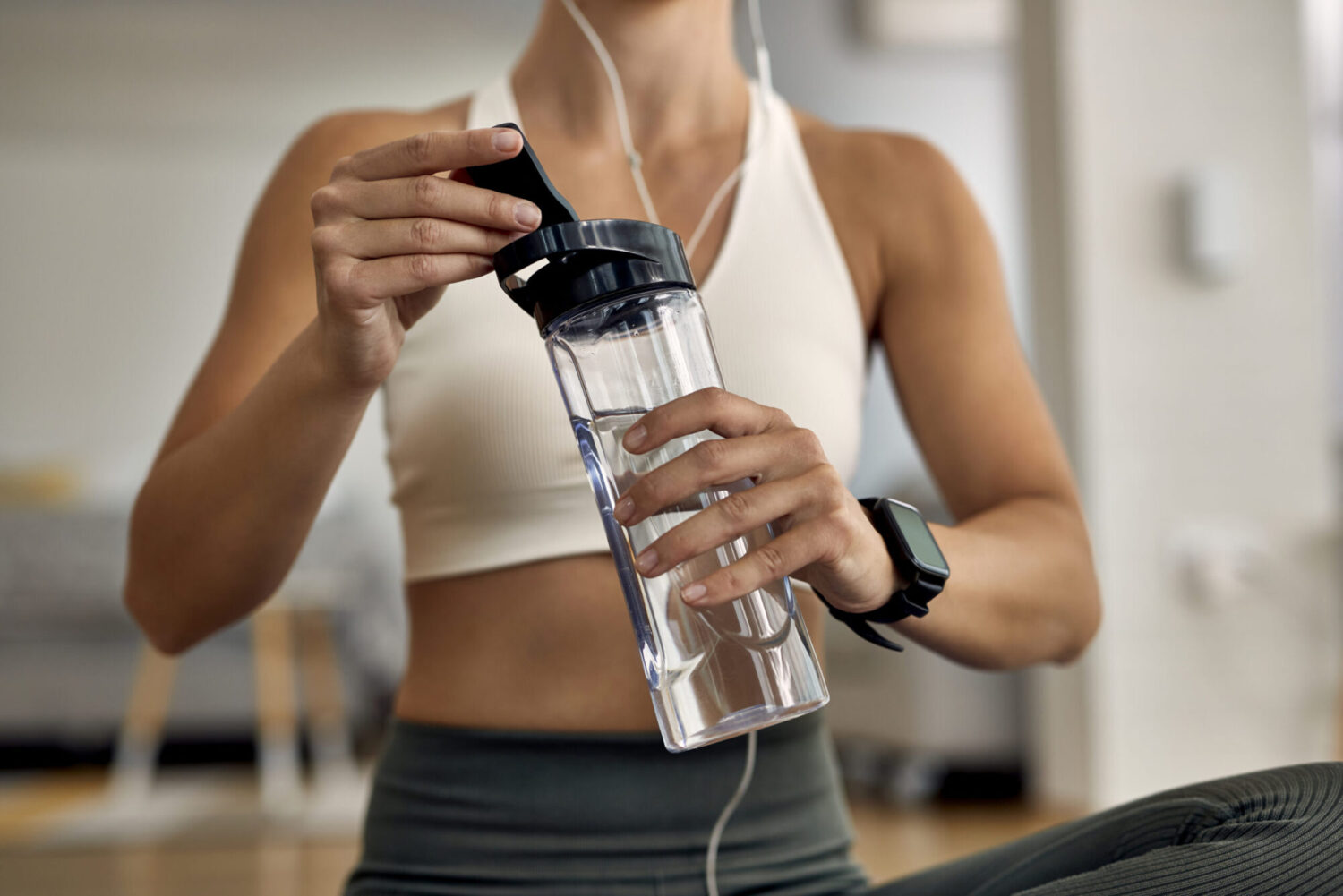 female in workout gear holding a water bottle