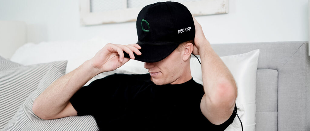 Man in bed with Red Light Cap on