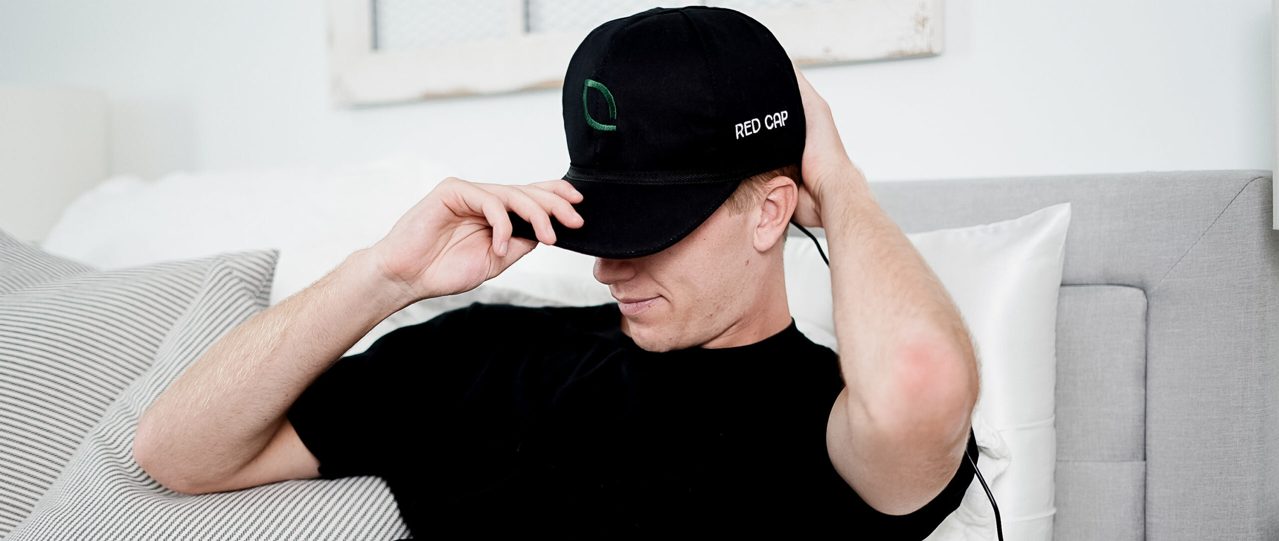 Man in bed with Red Light Cap on