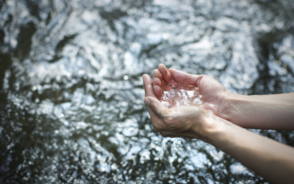 Man cupping his hands scooping water