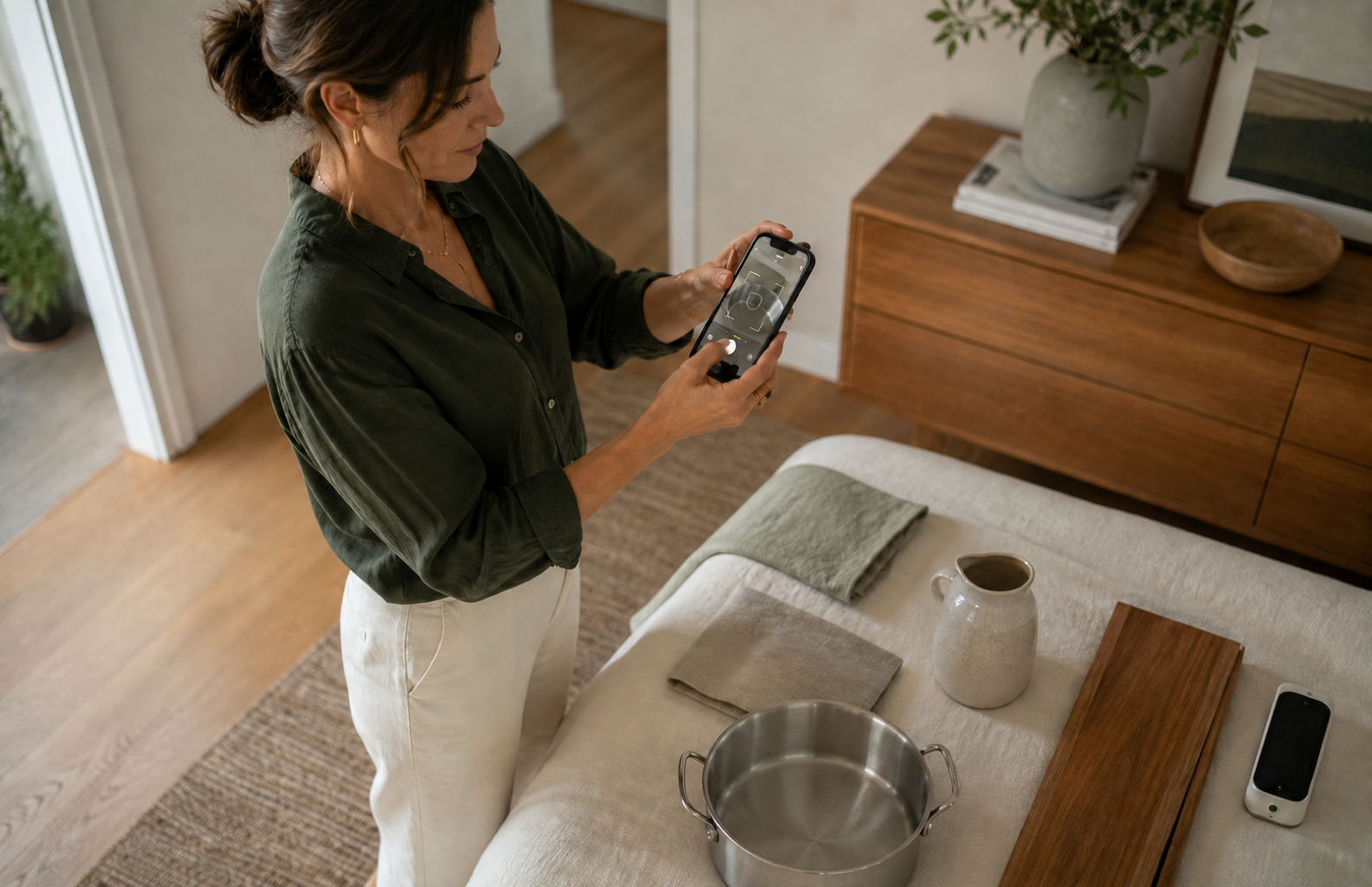 A woman using her phone to examine materials in her home